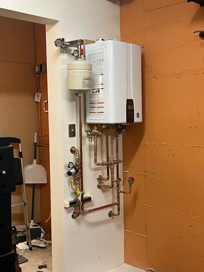 Plumbing technician inspecting water heater connections in East Orange
